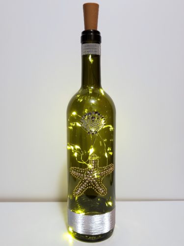 Bottle light with a jewelled starfish and seashell.