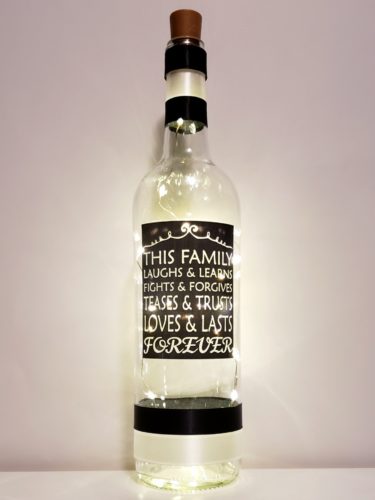 Bottle light with "This family laughs & learns, Fights & Forgives, Teases & Trusts, Loves & Laughs, Forever".