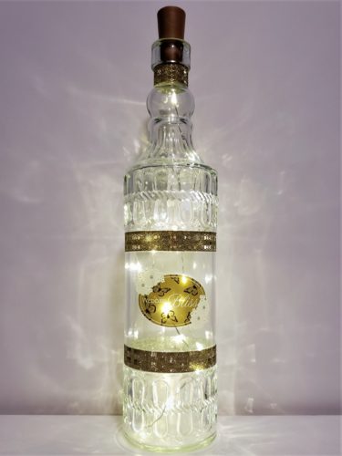 Bottle light featuring "Wedded Bliss" in gold and with white flowers.