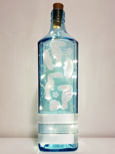 Bottle light with sparkly white toucans and tropical foliage.