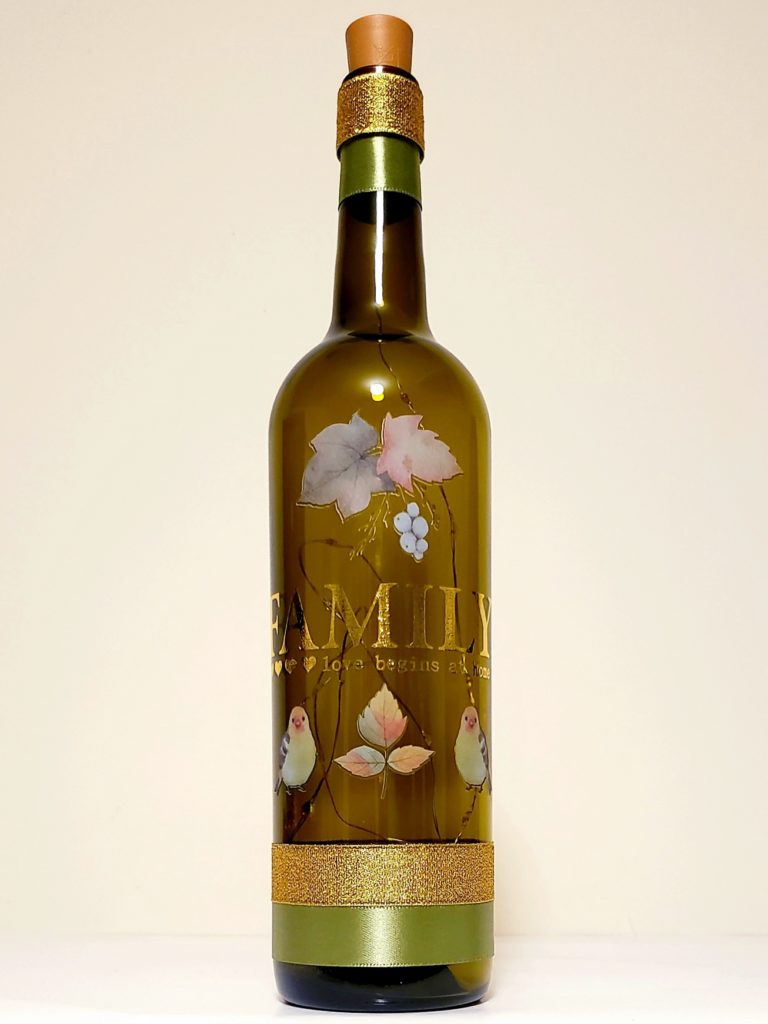 Bottle light with "Family: Love begins at home" surrounded by fall foliage and birds.