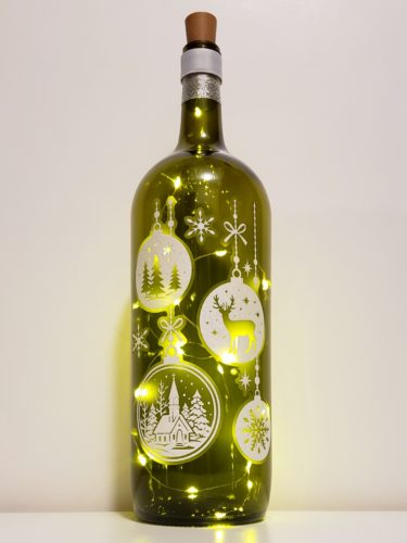 Bottle light with two sets of hanging ornaments in a white sparkly finish and with Christmas icons inside.