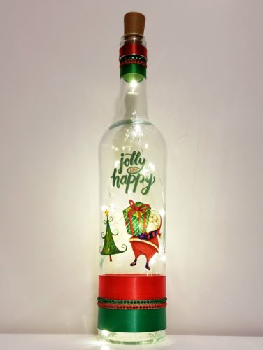 Bottle light with a Santa carrying a present, a Christmas tree, and "Jolly and happy".