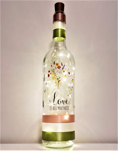 Bottle light featuring "Love is all you need" and a wildflower bouquet.