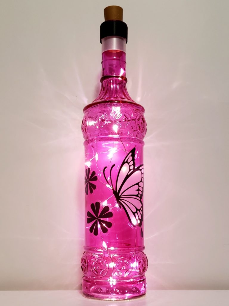 Bottle light with a pink finish featuring a black and white butterfly and flowers.