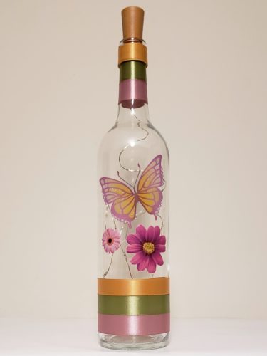 Bottle light featuring two flowers and a magenta and orangey butterfly.