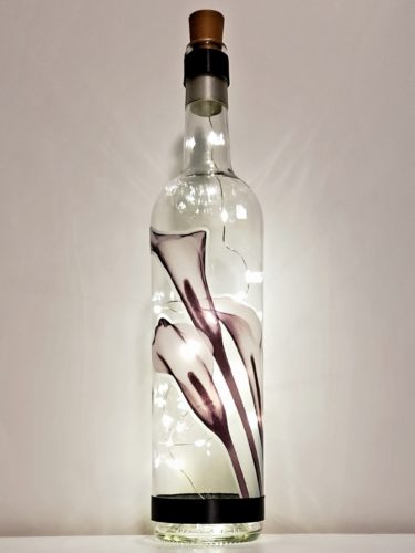 Bottle light with black and white calla lilies.