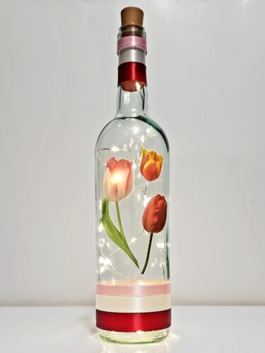 Bottle light with three tulips.