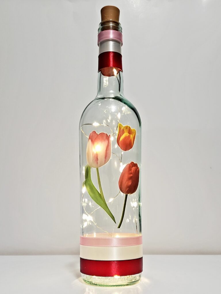 Bottle light with three tulips.