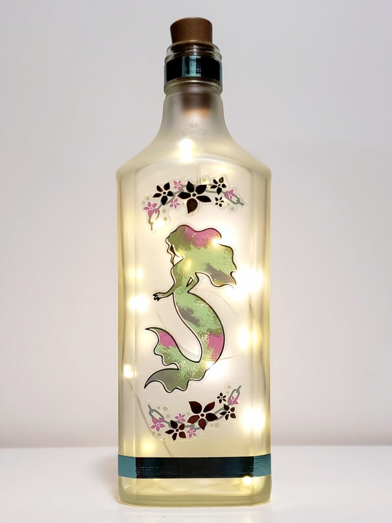 Mermaid bottle light with coral, and cold accents.