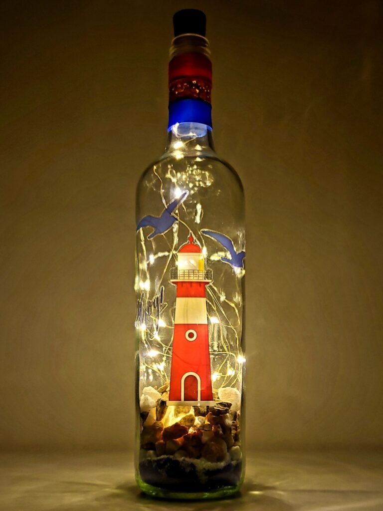 Lighthouse bottle light with sand and stones