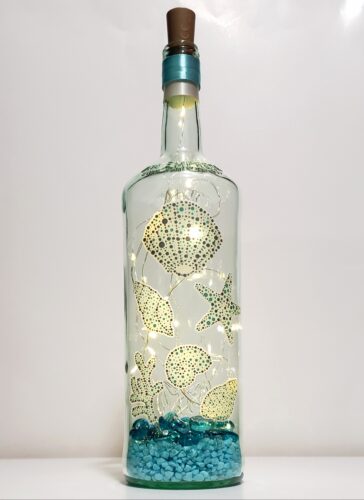 Bottle light featuring seashells with glass stones and pebbles